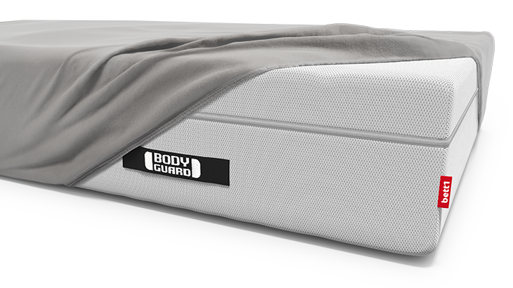 Die BODYGUARD Boxspring-Matratze ist bis auf eine Ecke bezogen mit dem BODYGUARD Spannbettlaken extra hoch