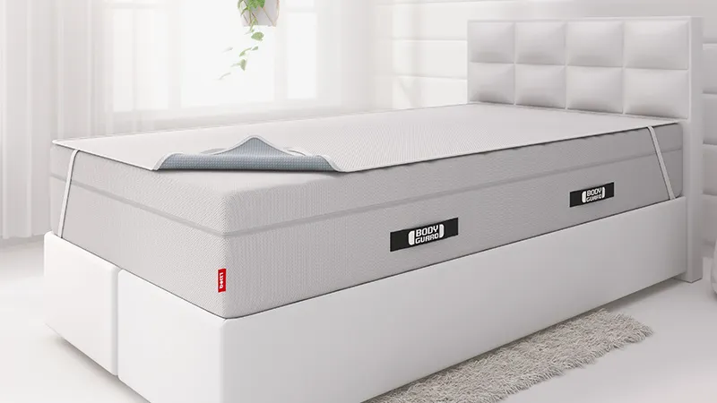 Auf einem Boxspringbett, liegt die BODYGUARD® Boxspring Matratze und darauf die BODYGUARD® Inkontinenzauflage.