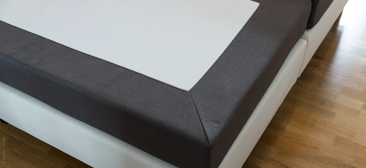 Foto: Die Ecke eines Boxspring-Bettgestells ohne Matratze darauf.
