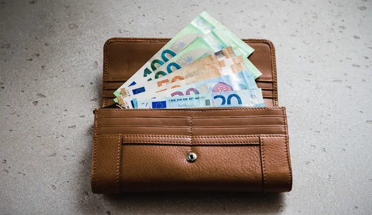 Ein Portemonnaie, aus dem verschiedene Geldscheine herausschauen