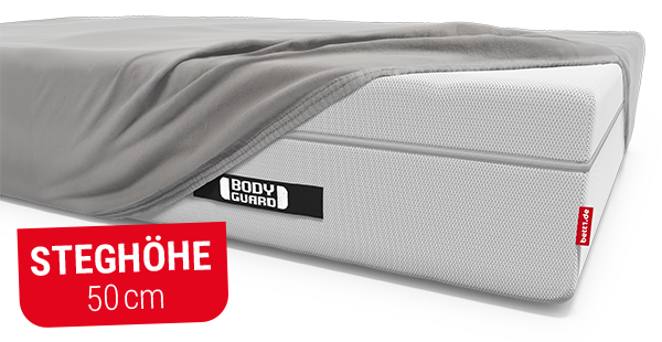 BODYGUARD Boxspring Matratze, die halb mit einem BODYGUARD Spannbettlaken extra hoch bezogen ist. Text: Steghöhe 50 cm.