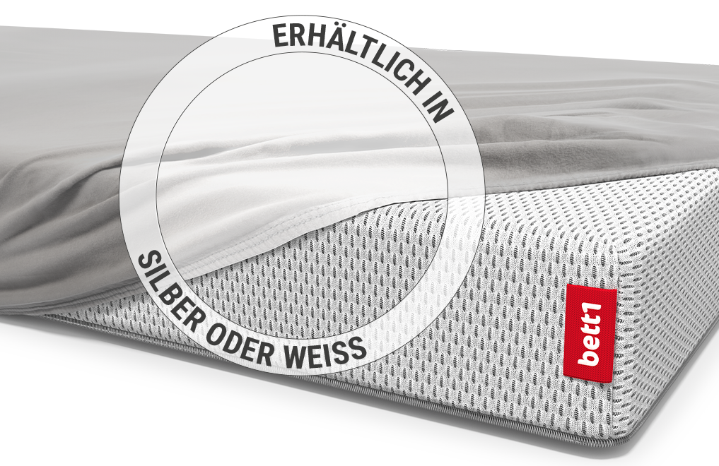 Die BODYGUARD® Kindermatratze ist bis auf eine Ecke mit dem Kinder-Spannbettlaken in Silber bezogen. Zoom auf das Laken in der weißen Farbvariante.  Text: Erhältlich in Silber oder Weiß