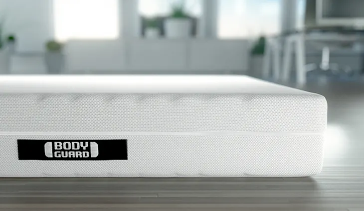 Die BODYGUARD Matratze liegt auf einem Holzboden.