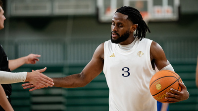 Foto: Ein Spieler der Berlin Dreams hält einen Basketball und klatscht Personen ab.
