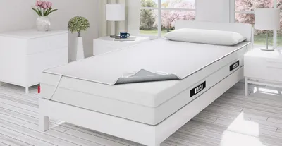 Foto: Ein helles Schlafzimmer mit Einzelbett. Darauf liegt die BODYGUARD Matratze mit BODYGUARD Inkontinenzauflage.