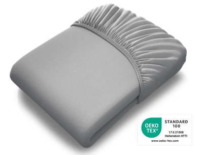 Das BODYGUARD® Spannbettlaken extra hoch zusammengelegt, darüber das Oeko-Tex® Standard 100 Siegel	